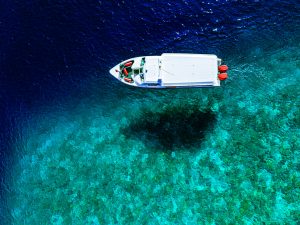 A white boat floating on clear turquoise water.