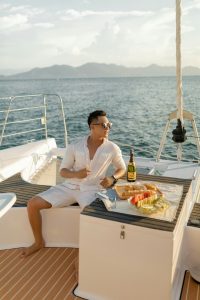Man enjoying a private yacht dining experience in Playa del Carmen with champagne and fresh fruit on deck