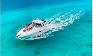 Private luxury yacht cruising through turquoise Caribbean waters near Playa del Carmen during a yacht rental charter experience.