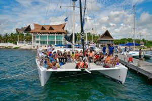 Group of guests boarding a catamaran at a marina near Playa del Carmen for a Caribbean sailing and snorkeling tour.